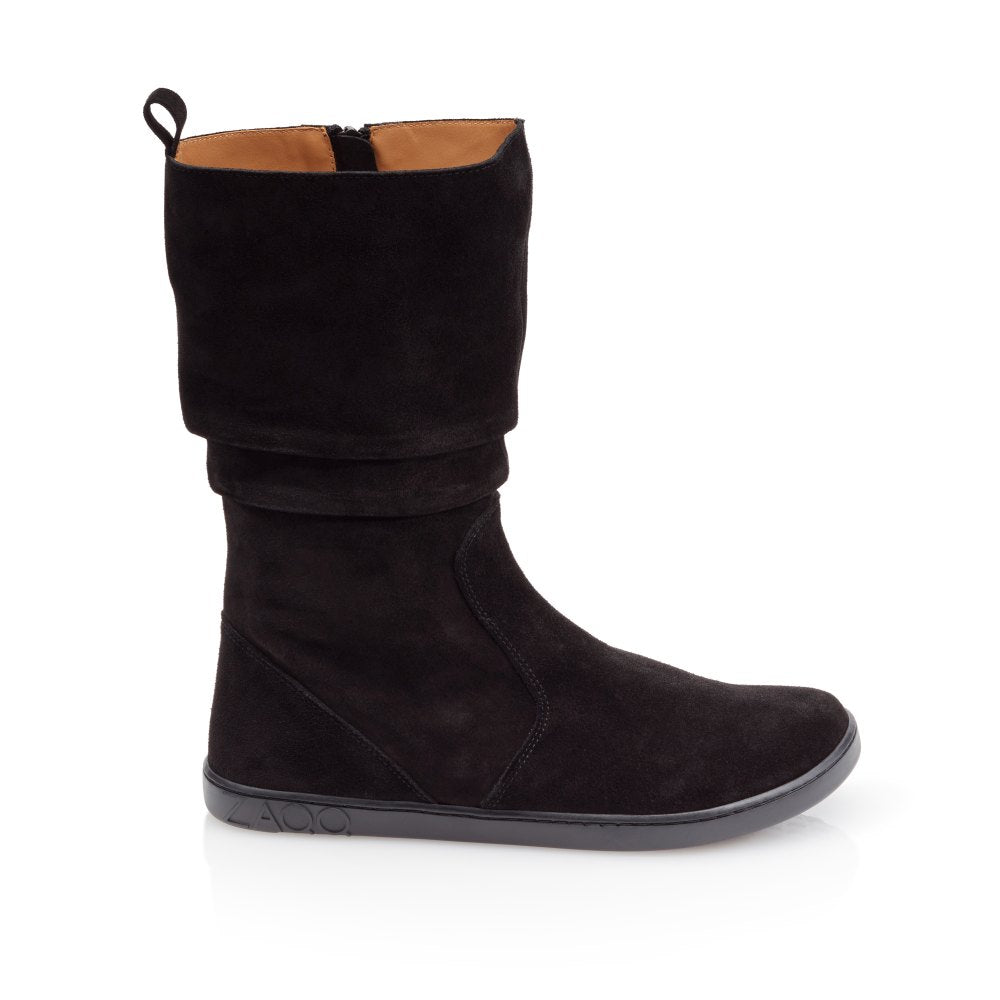 ZAQQ QOM Black to buty sięgające kolan, wykonane z czarnego zamszu z płaską podeszwą i subtelnymi szwami widocznymi z boku. Mają u góry wywinięty mankiet, są wykonane z miękkiej skóry nappa i posiadają zamek błyskawiczny do zamykania.