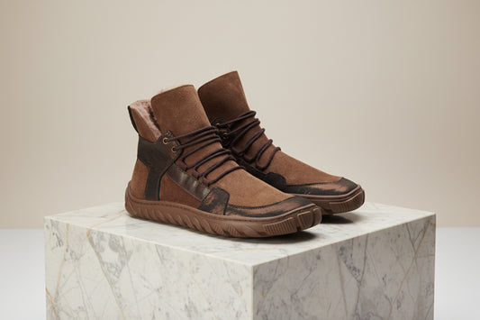 Der ALPIQ Winter Bronze von ZAQQ ist ein brauner High-Top-Sneaker aus Veloursleder mit dunkelbraunen Akzenten, dicken Schnürsenkeln und einer robusten Ultragrip-Sohle für hervorragenden Halt, perfekt für die Freizeit.