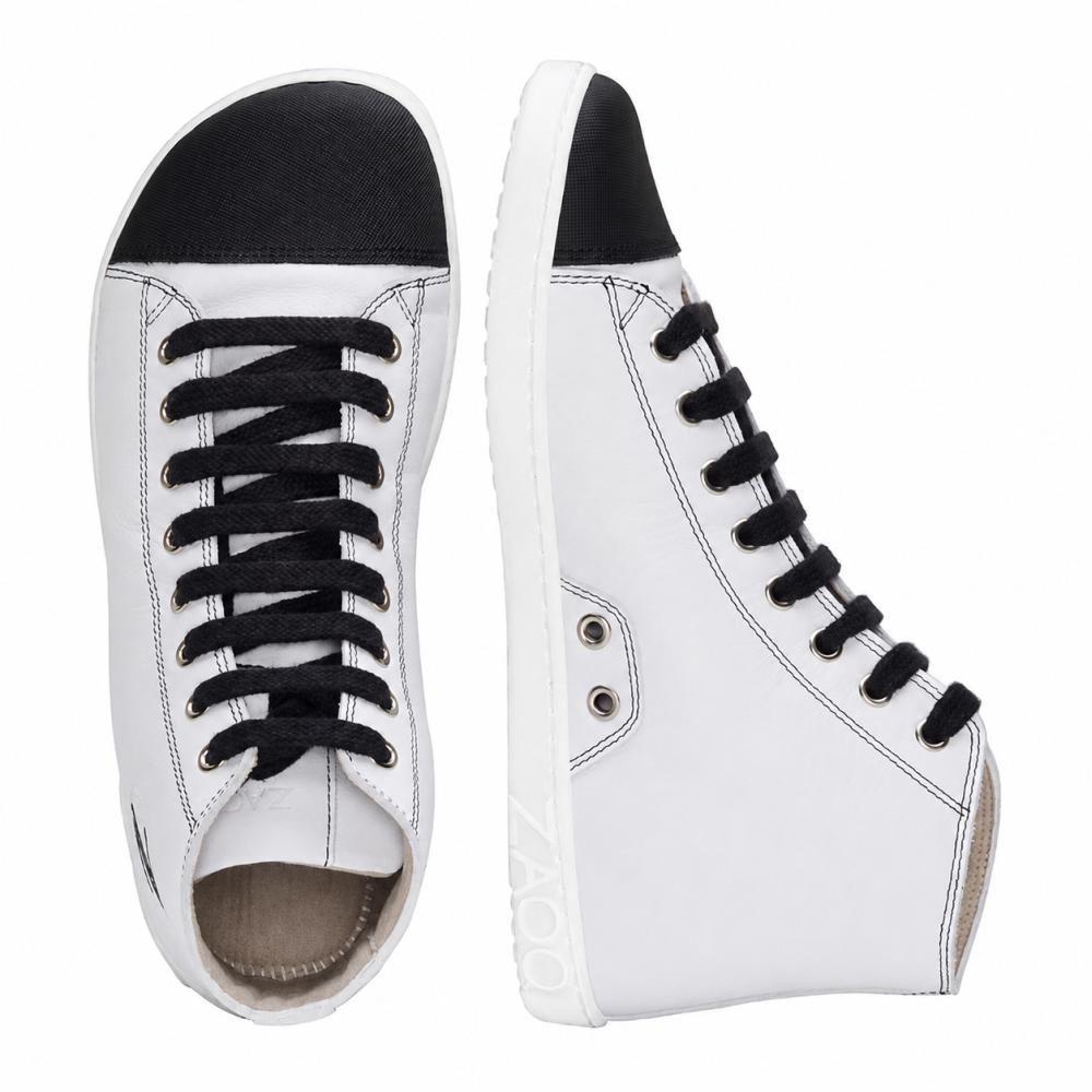 Prezentujemy CHUQQS White od ZAQQ: elegancką parę białych sneakersów High-Top z czarnymi sznurówkami i osłonami na palce. Lewy but jest widoczny od góry do dołu, podczas gdy prawy stoi pionowo, pokazując swój profil boczny. Te sneakersy są mistrzowsko wykonane z nappa skóry i mają białe podeszwy z nazwą marki ZOOZ.