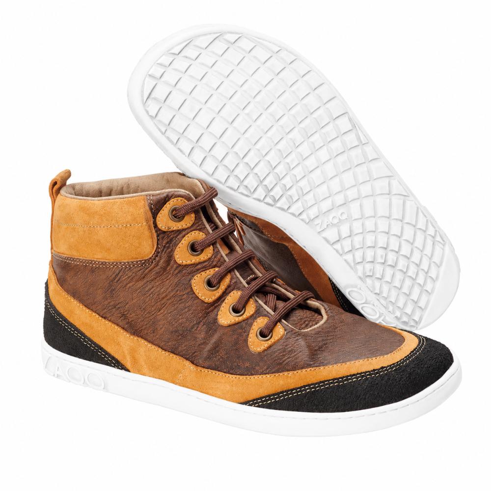 Para modnych ZAQQ CINQO Brown High-Top-Sneaker w odcieniach brązu i pomarańczy z czarnymi akcentami i białą podeszwą z miękkiej skóry nappa. Jeden but stoi pionowo, podczas gdy drugi leży na boku, co podkreśla strukturalny design podeszwy, który zapewnia komfort buta boso.
