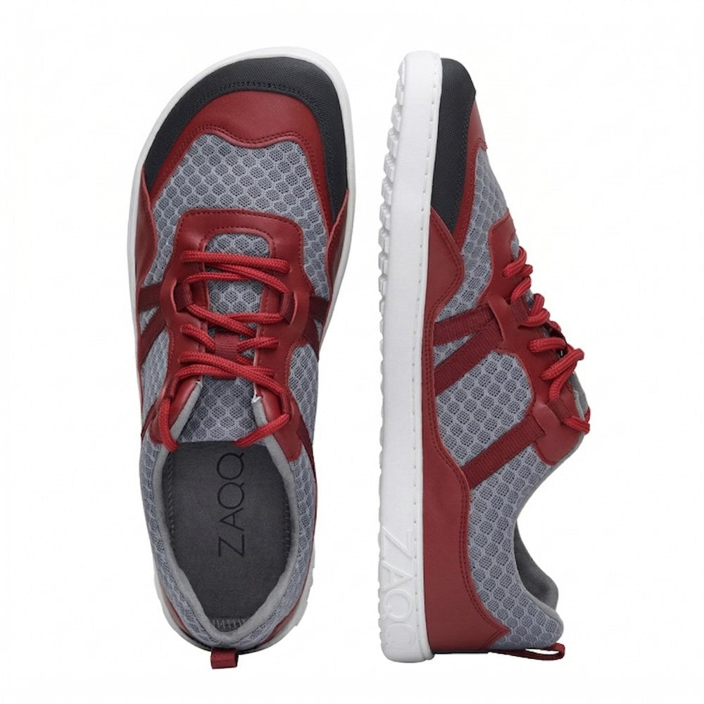 Ein Paar Sportschuhe von ZAQQ, einer von oben und der andere von der Seite, mit einem rot-grauen Design. Sie sind aus Netzstoff gefertigt, mit roten Schnürsenkeln akzentuiert und haben eine weiße Sohle mit eingeprägtem Markennamen. Erleben Sie optimalen Komfort bei jedem Schritt mit diesen stylischen SQATE Red-Schuhen.